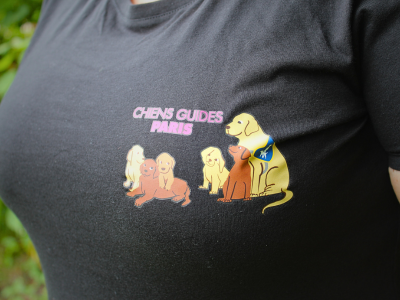 Gros plan t-shirt noir Chiens Guides Paris avec une illustration du pôle élevage (avec des chiots et la maman)