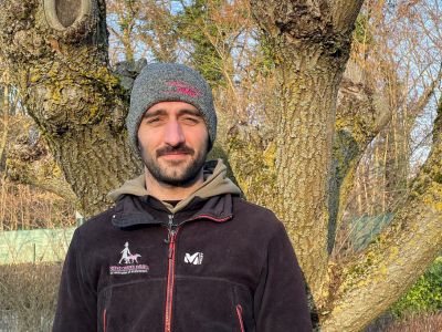 Bonnet sans pompon gris foncé, avec l'écriture brodé " Chiens Guides Paris " sur le devant en rose