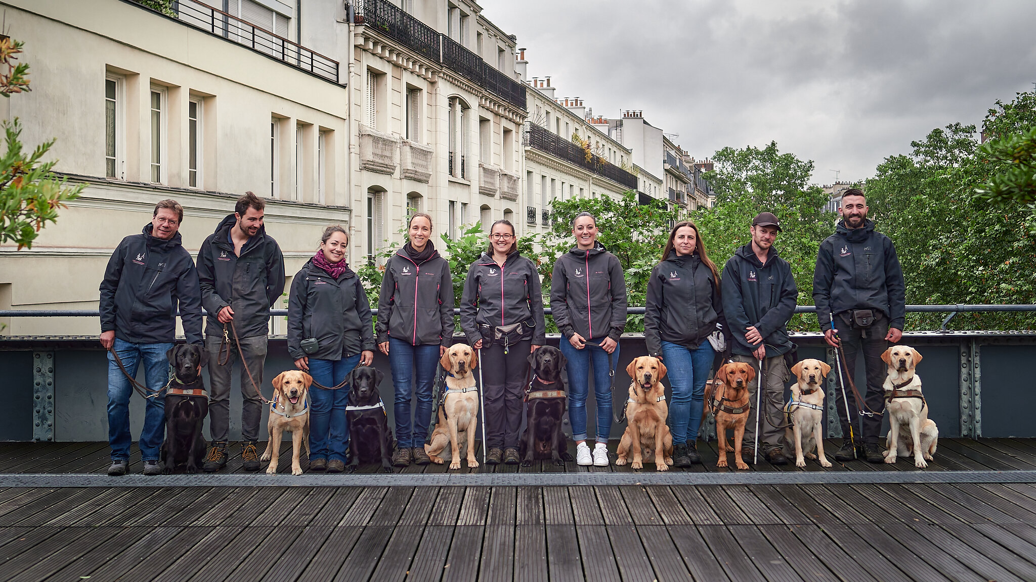 Photo de groupe sur un pont avec les éducateurs, moniteurs et leurs chiens.